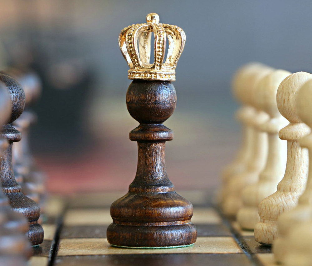 A chess peice with a gold crown on